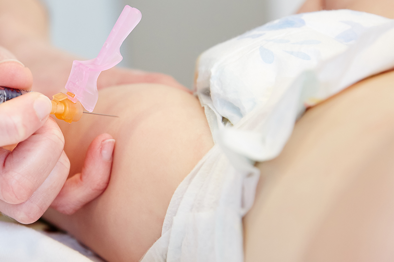 Close up van een baby die wordt gevaccineerd met een veilige naald.