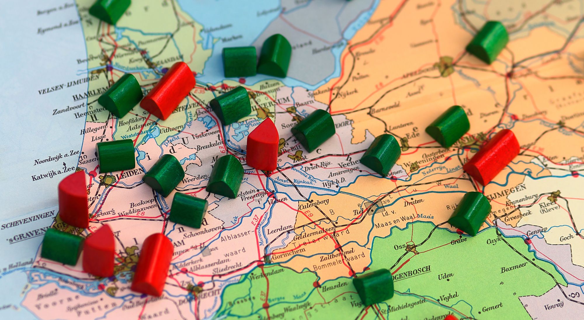 Rode en groene speelgoedhuisjes verspreid over de kaart van Nederland