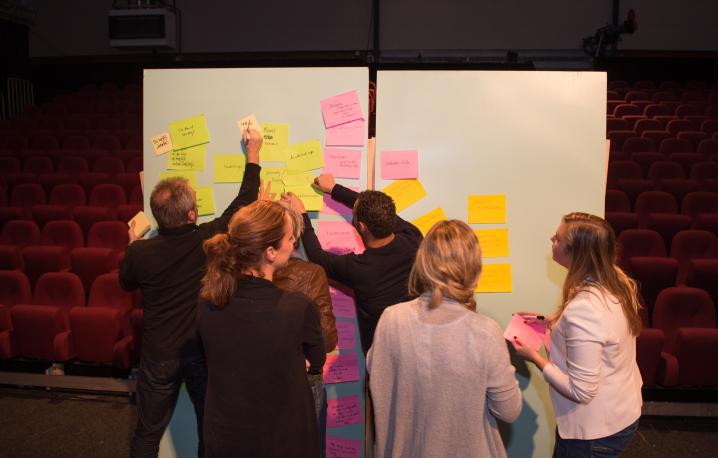 Workshopdeelnemers verzamelen ideeën via post its 